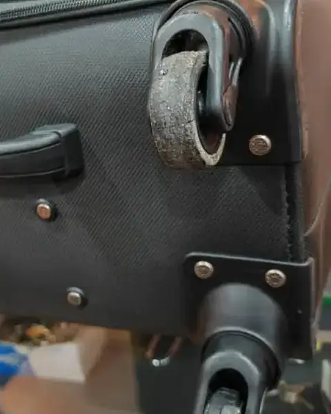 Suitcase with a broken spinner wheel, before repair