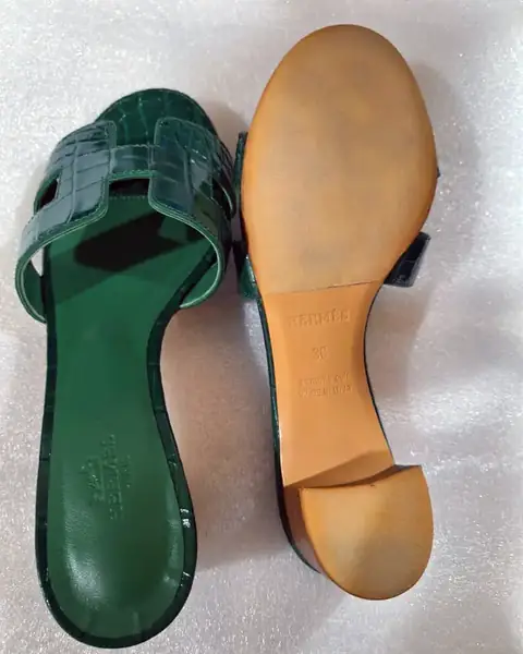Heeled sandal with a worn sole and heel tip, before repair