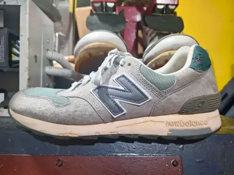 Running shoe with a yellowed, worn sole, before repair