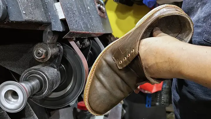 A shoe being finished on the grinding wheel at the KL Cobbler & Locksmith counter